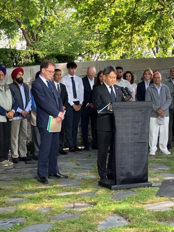 Consul General Takahashi delivering remarks and observing a moment of silence.